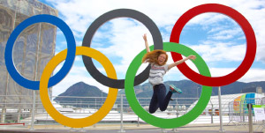 Girl jumping in front of Olympics logo