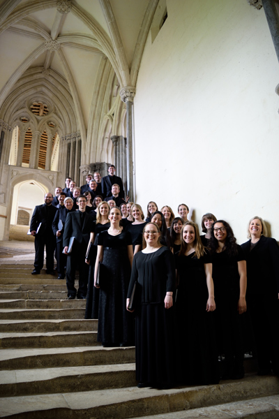 Choir in black dress posing on stairs in a cathedral