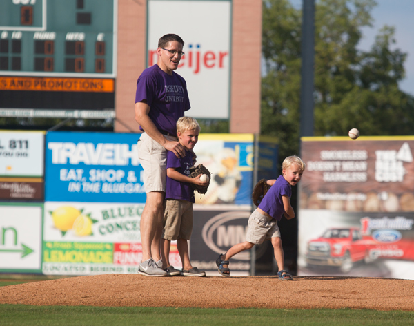 Charlie Shepard and his two sons throwing the first pitch at a baseball game