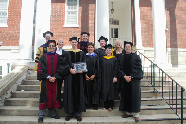 Faculty in robes posing for a photo