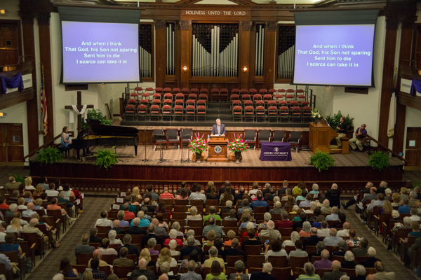 Hughes Auditorium filled with people singing hymns