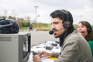 Students with headsets commentating on a go-cart race