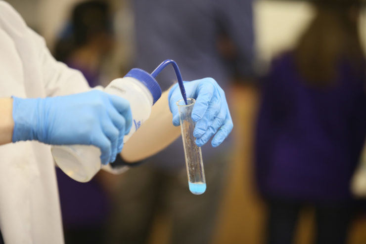 person injecting a liquid into a test tube