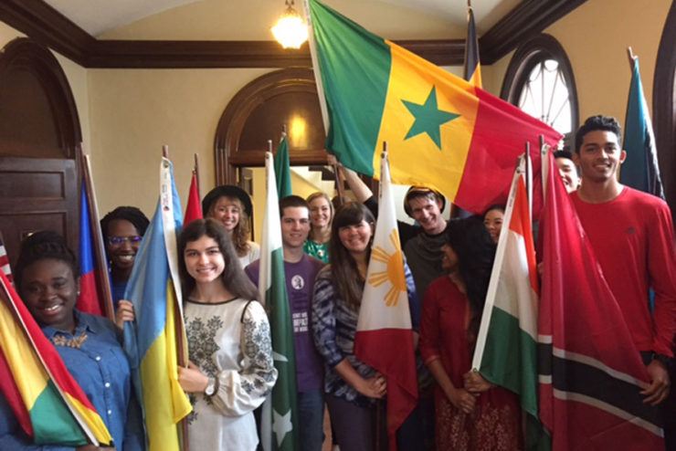 students smiling and holding flags