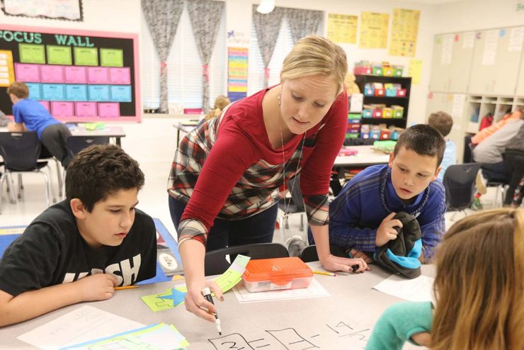 teacher working with kids in an elementary classroom