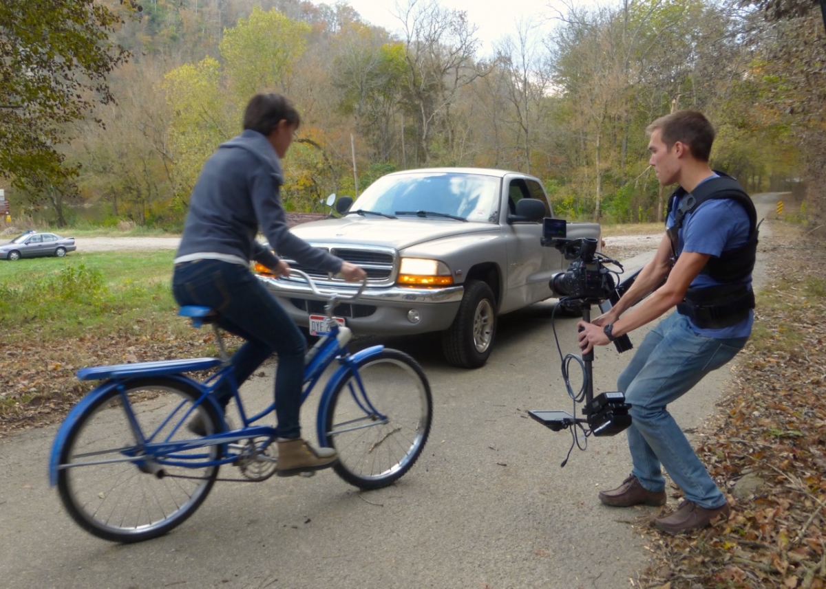 Students filming a scene with a bicycle and car