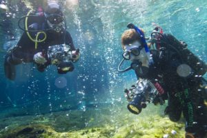 Students in scuba gear filming underwater