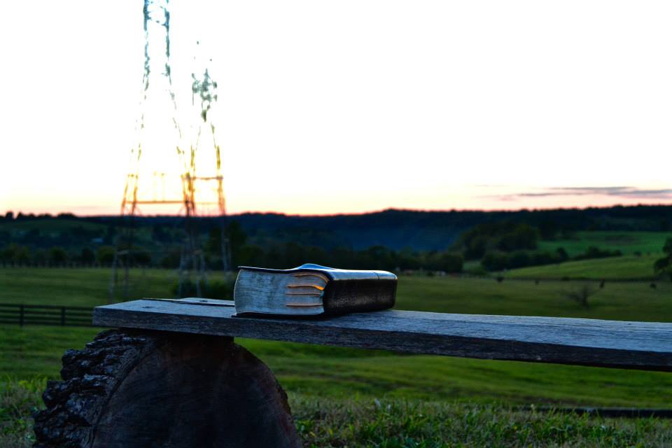 a Bible on a bench in the sunset