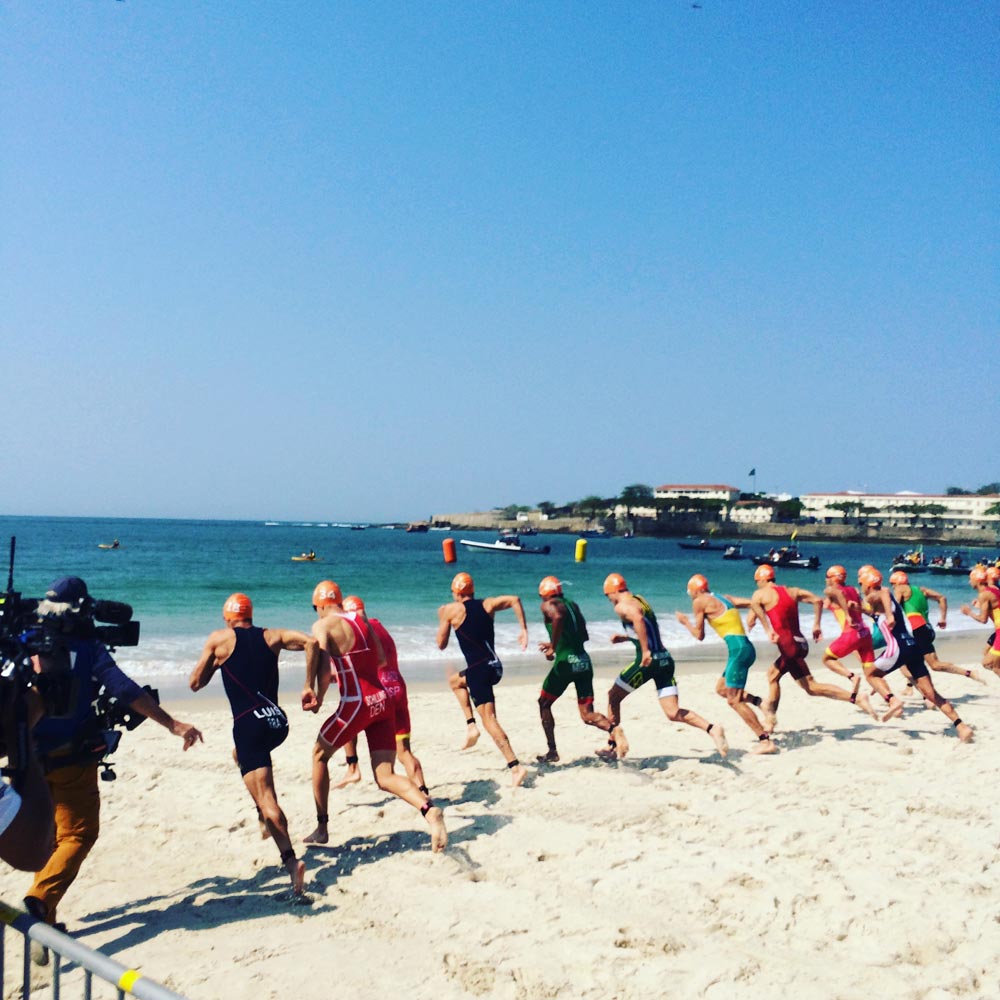row of Olympic triathletes racing to the ocean