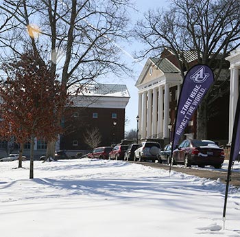 Snowy road in front of Hughes Auditorium
