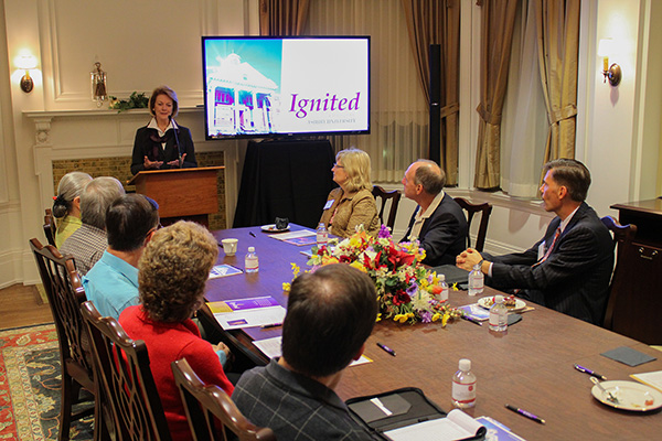 Dr. Gray presenting to people sitting around a conference table