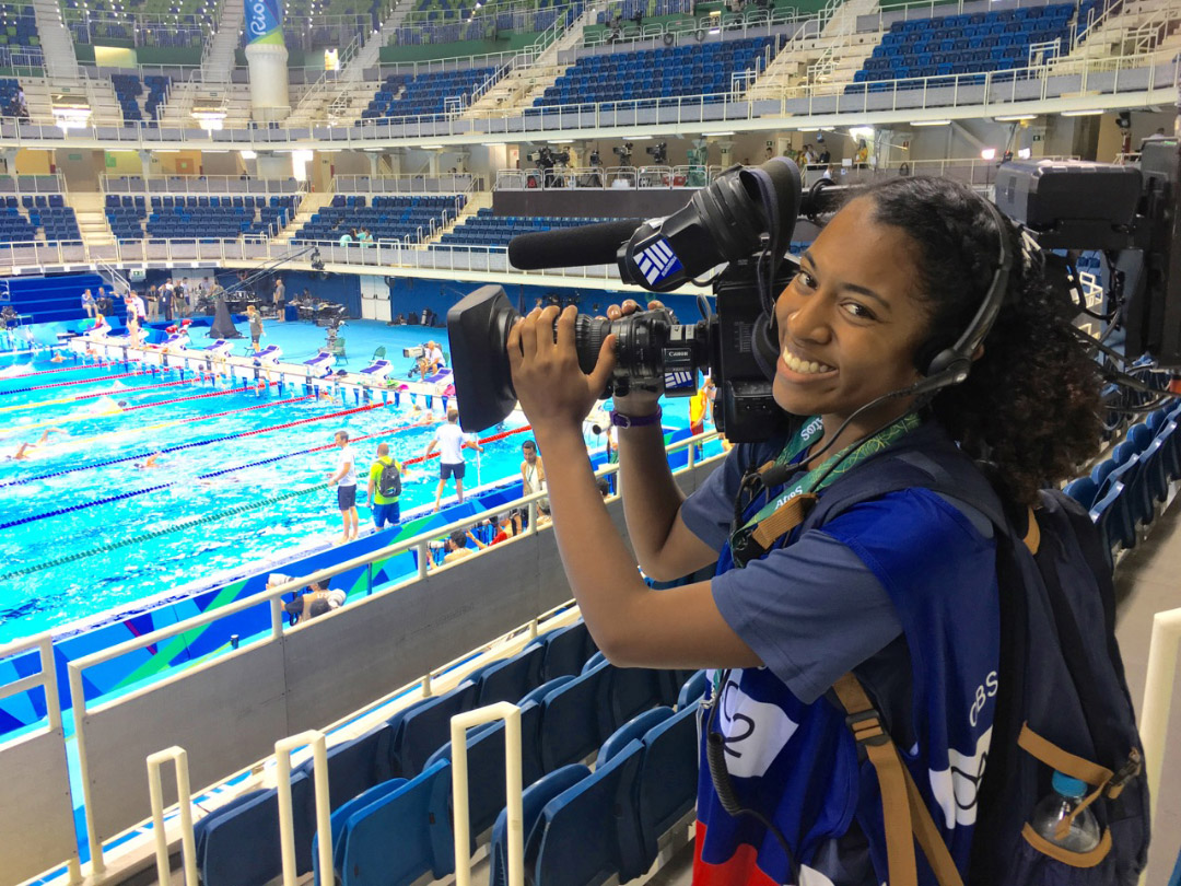 Student holding a TV camera at the Olympics