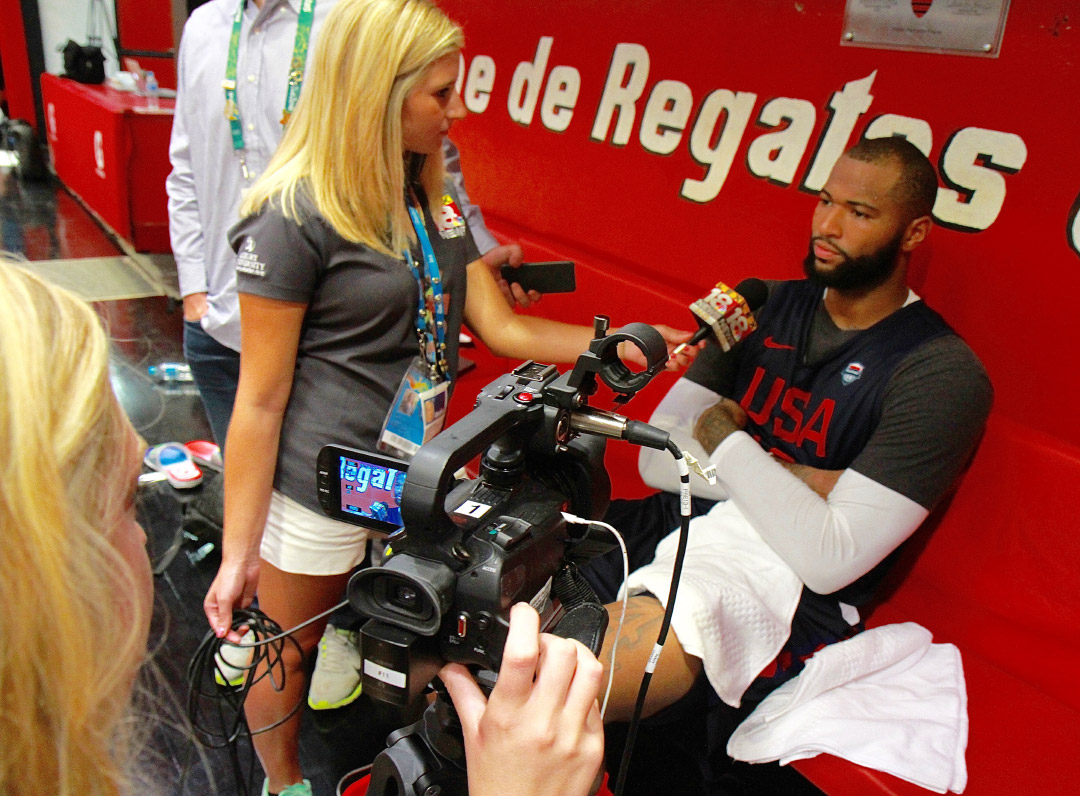 student interviewing a team member of the USA Basketball Team at the Olympics