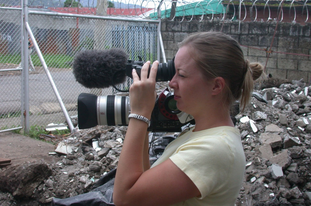 Student with camera filming disaster devastation