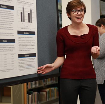 Student making a presentation at a poster