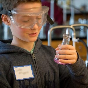 boy holding a flask with colored liquid