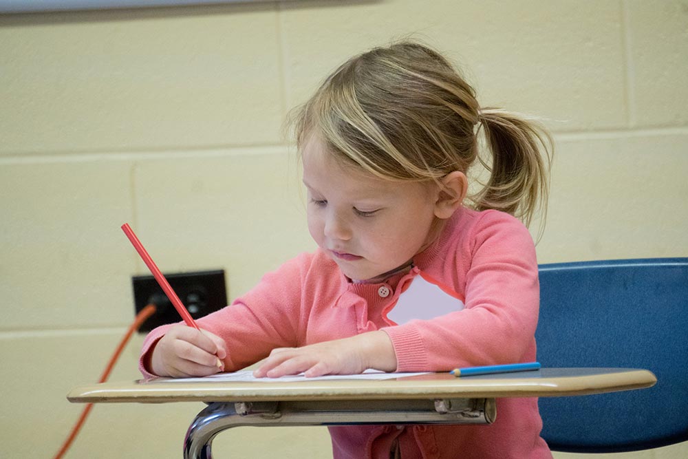 child writing at a desk
