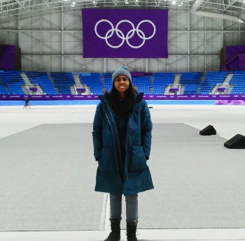 Student standing on an Olympic ice rink