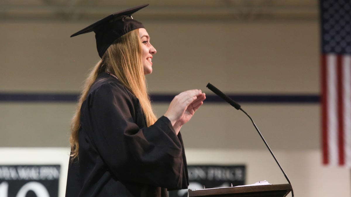 student leading the singing at commencement