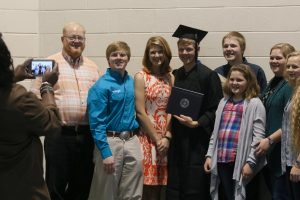 graduate with family smiling for the camera