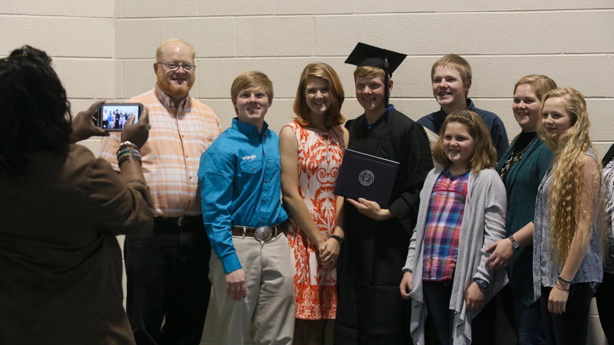 graduate with family smiling for the camera