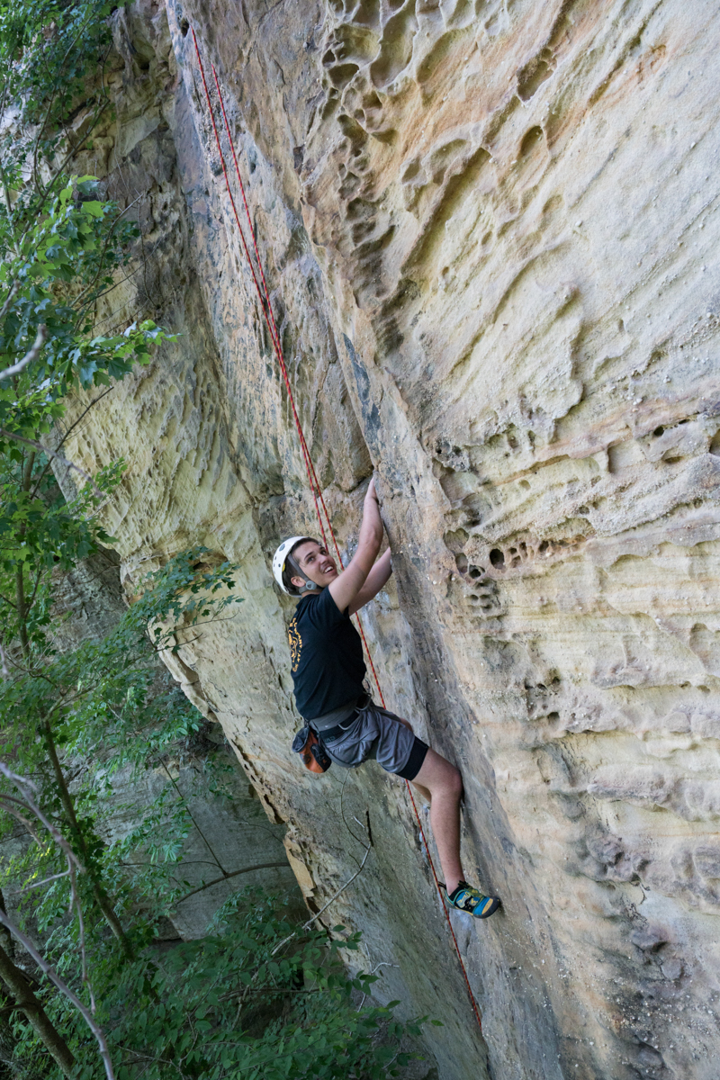 student climbing a cliff face