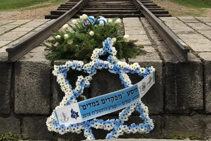 Cross of David and flowers by an old railroad track at a concentration camp