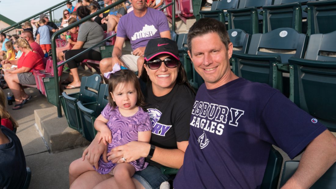 family in the stands at a baseball field