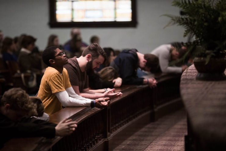 students praying at the altar in Hughes Auditorium