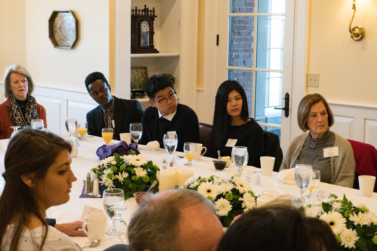 students, faculty, and administrators around a banquet table