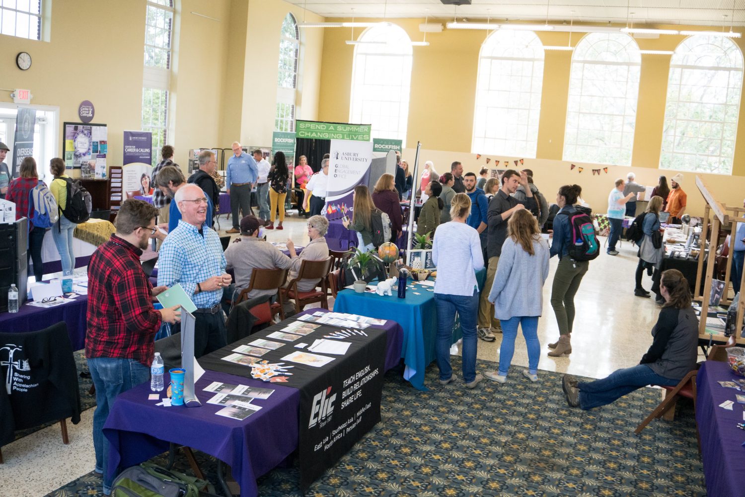 students standing and talking at a missions fair