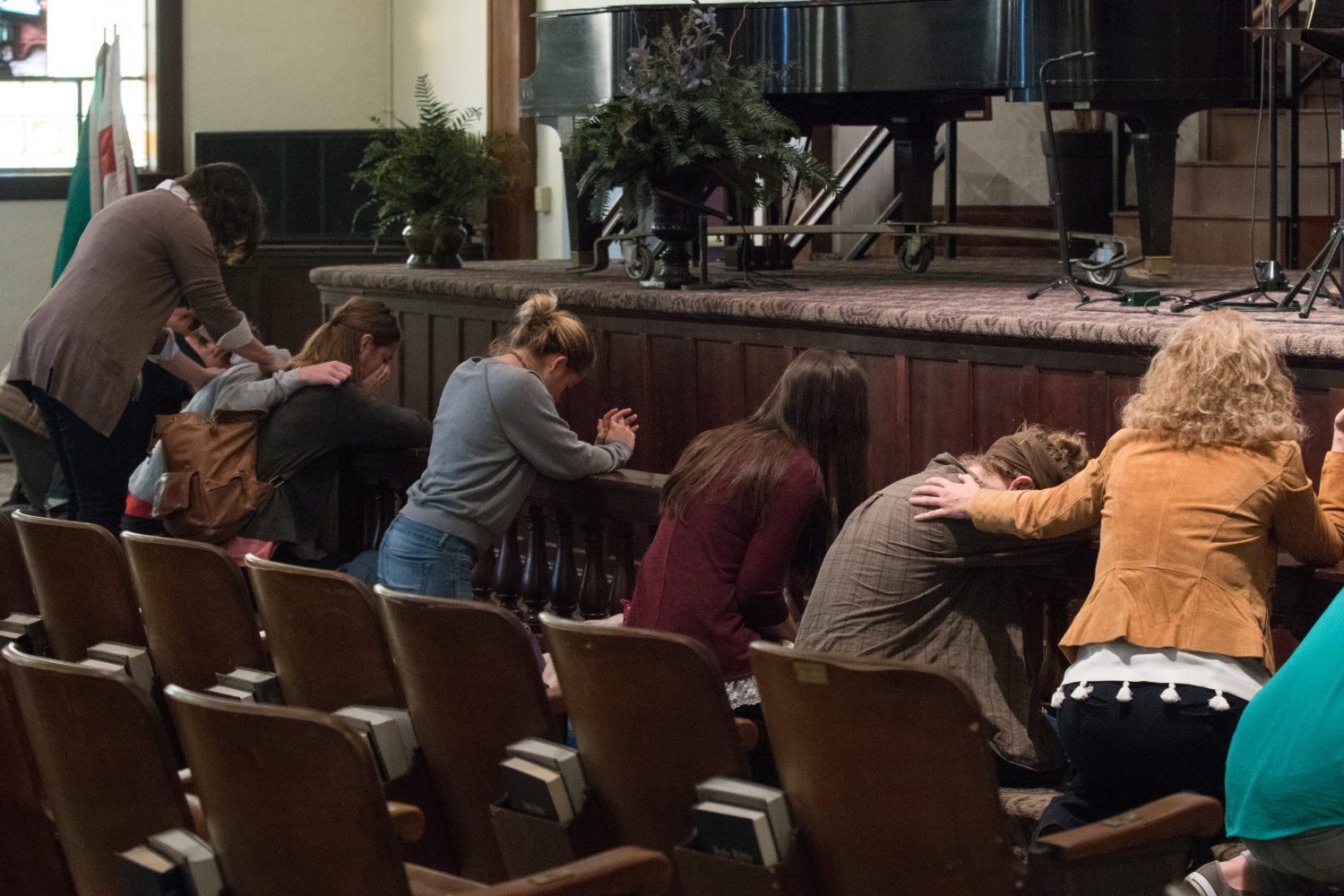 students praying at the altar in Hughes Auditorium