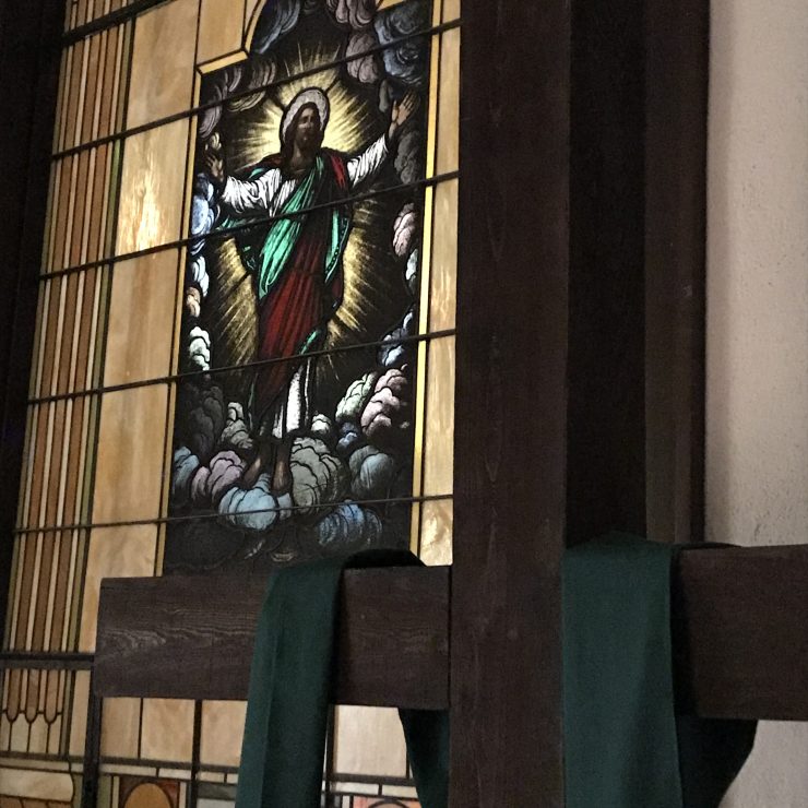 a cross next to a stained glass window