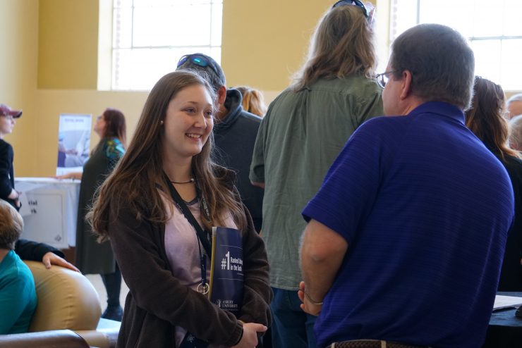prospective student at Access Day talking with a faculty member