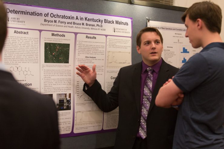 student giving a poster presentation of research