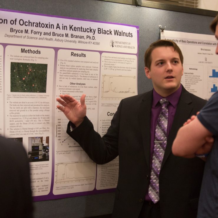 student giving a poster presentation of research