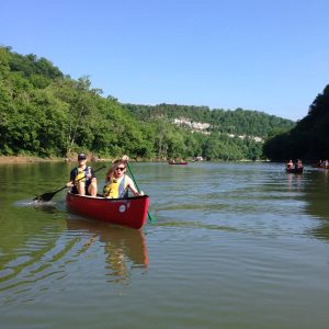 people paddling a canoe on a lake