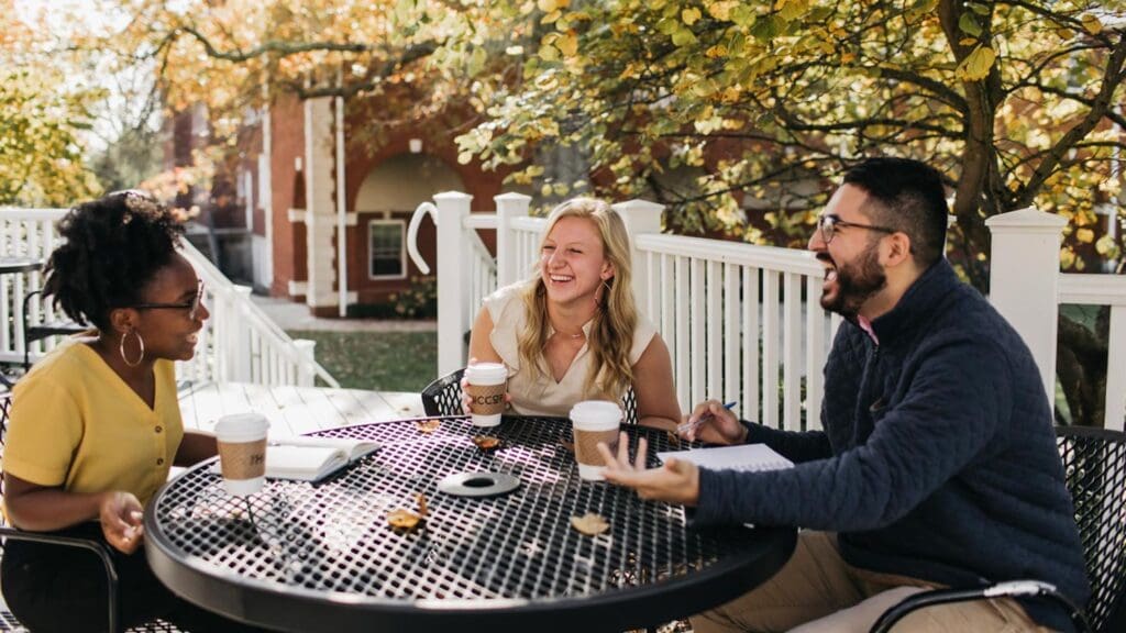 Students talking and laughing around a picnic table