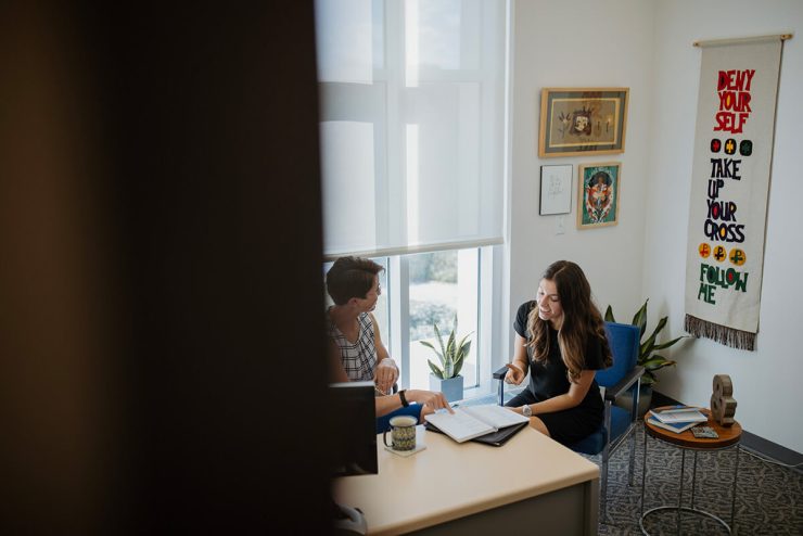 A female Asbury University student talks with an advisor in an office