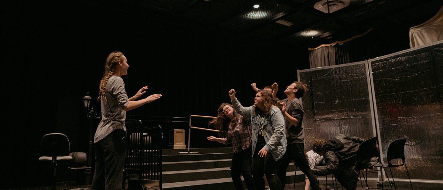 Six Asbury University students rehearse a production in a black box theater on campus