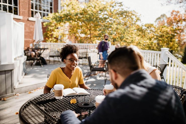 Two students drink coffee outdoors on Asbury University's campus