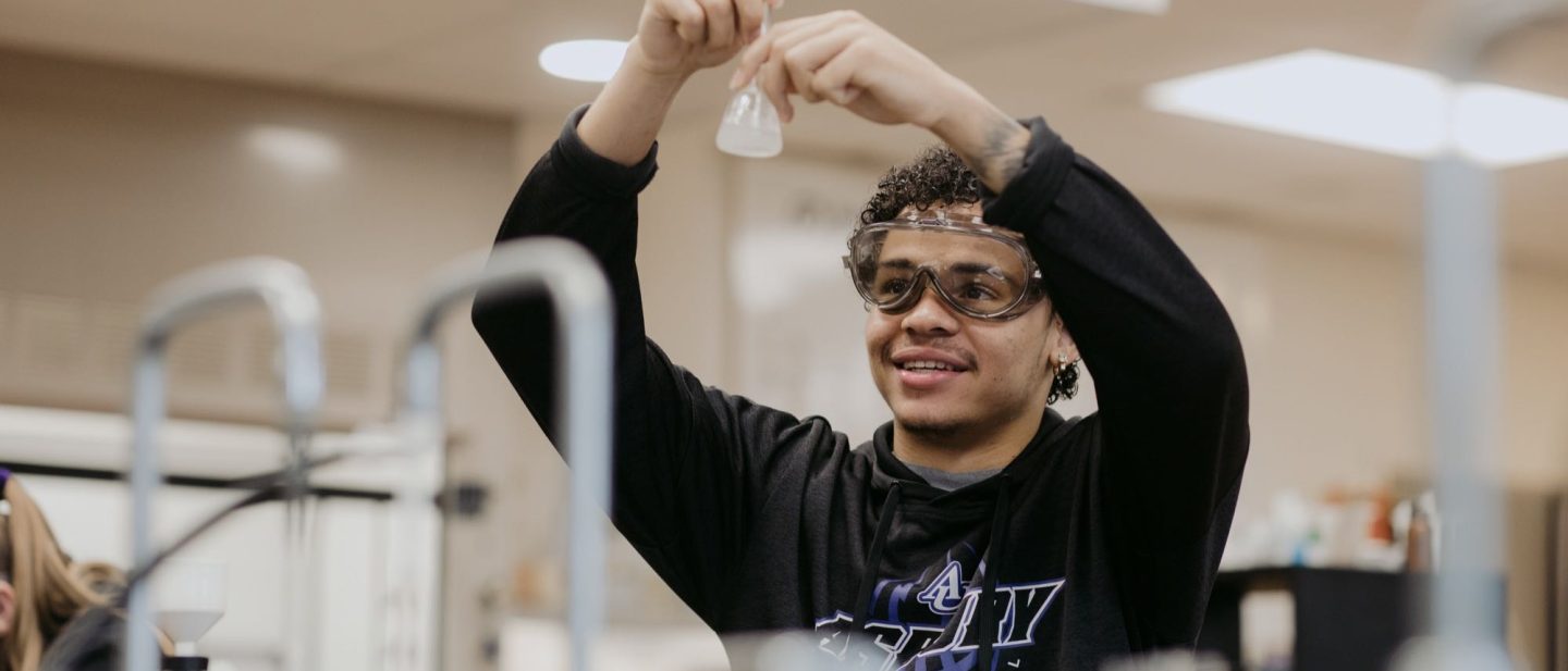 student holding a beaker in a science lab
