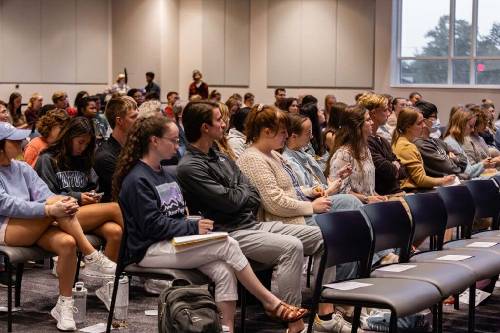 People sitting in chairs in a large room